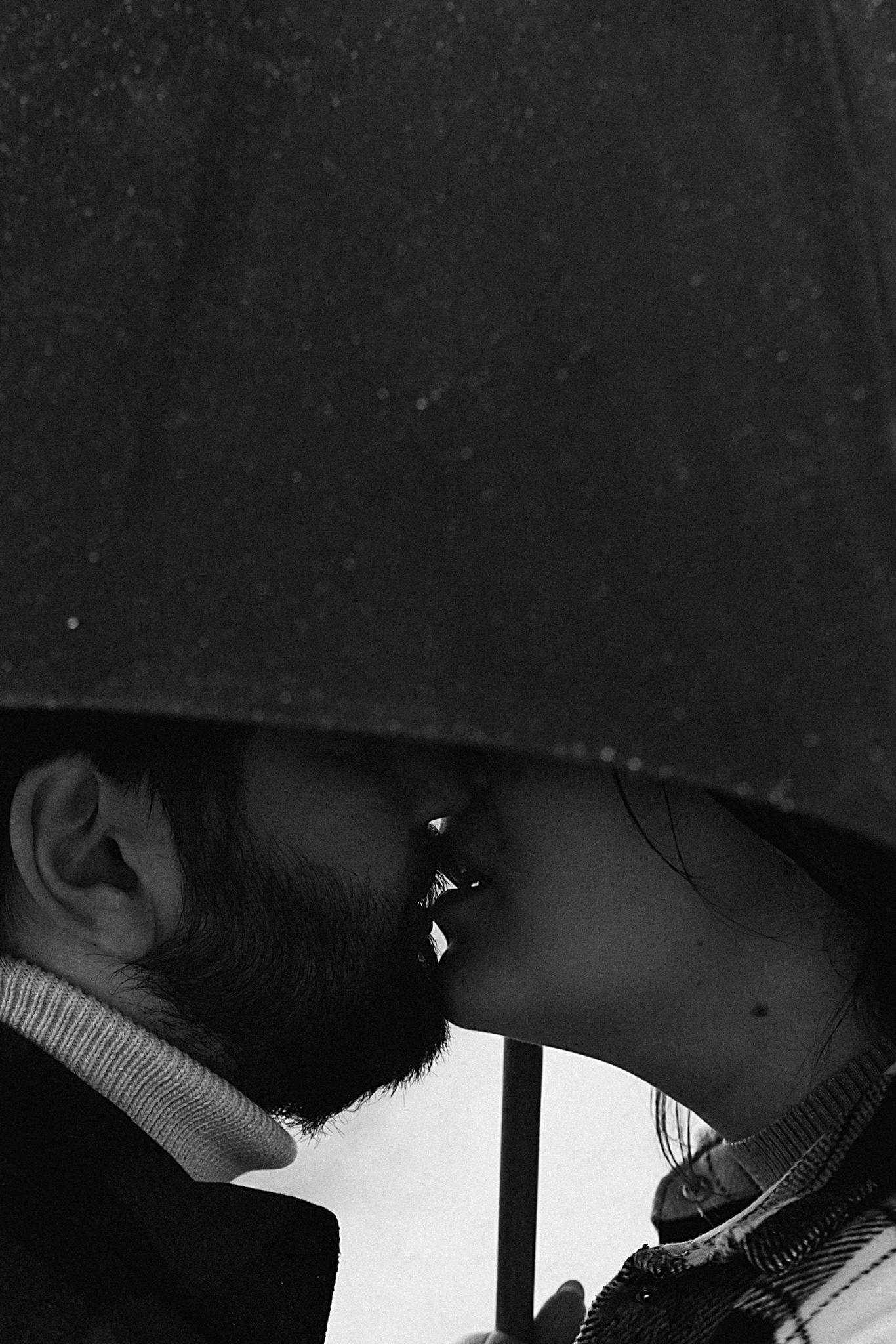 Creative couple photo, black-and-white photo of a couple kissing under an umbrella