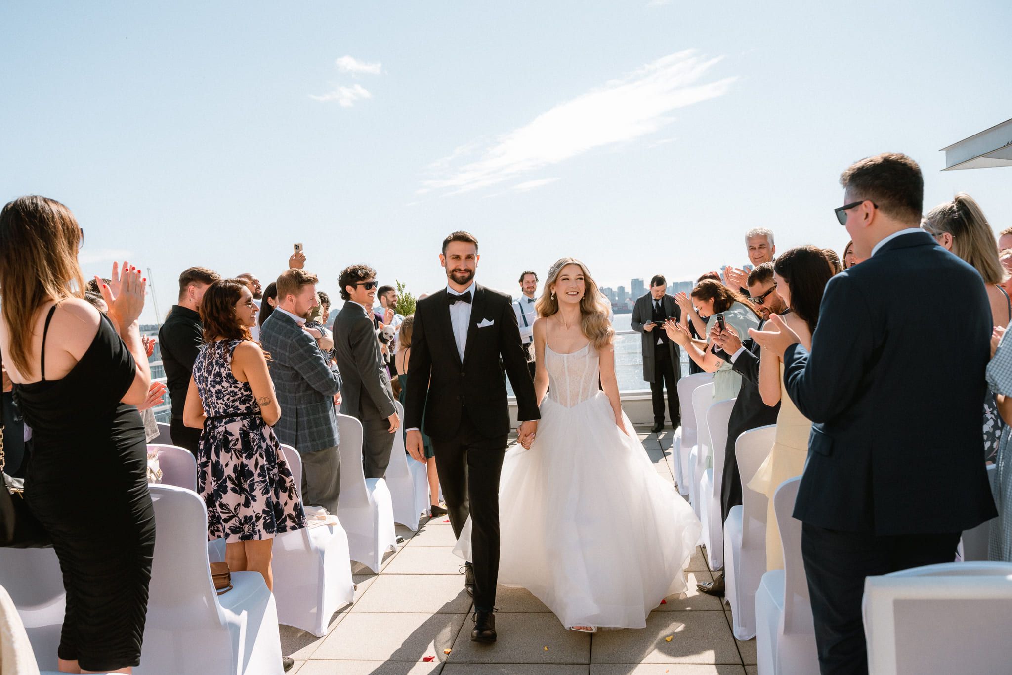 Groom photos on a rooftop, bride and groom walking up the aisle past cheering guests