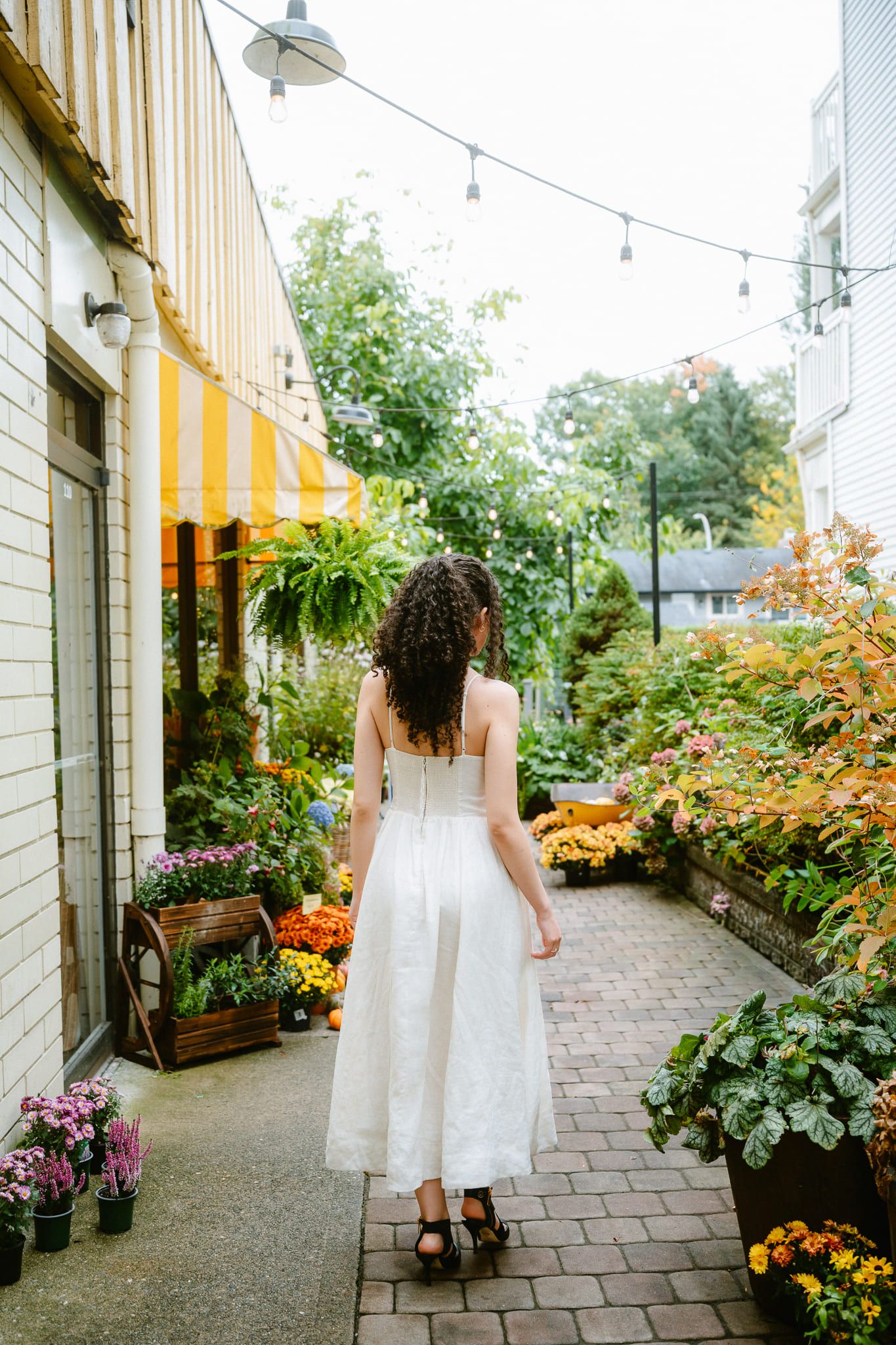 Urban portrait photography on a village street, woman with curly hair
