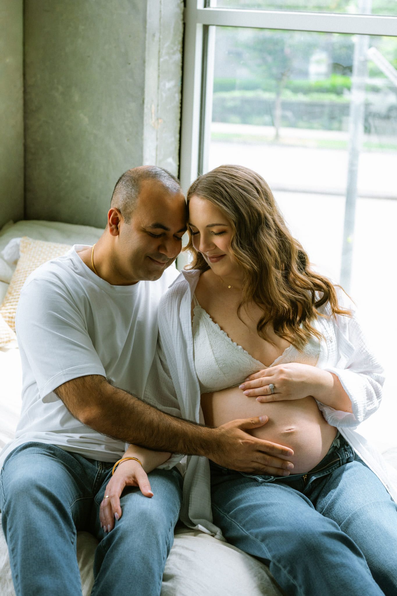 Pregnancy photos, expectant couple in a bright studio with plants