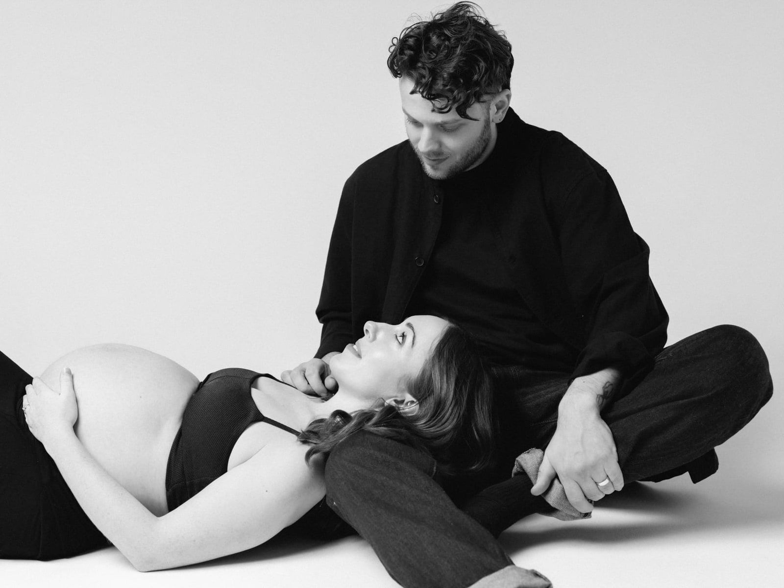 Black and white maternity shoot, expectant couple in a white studio