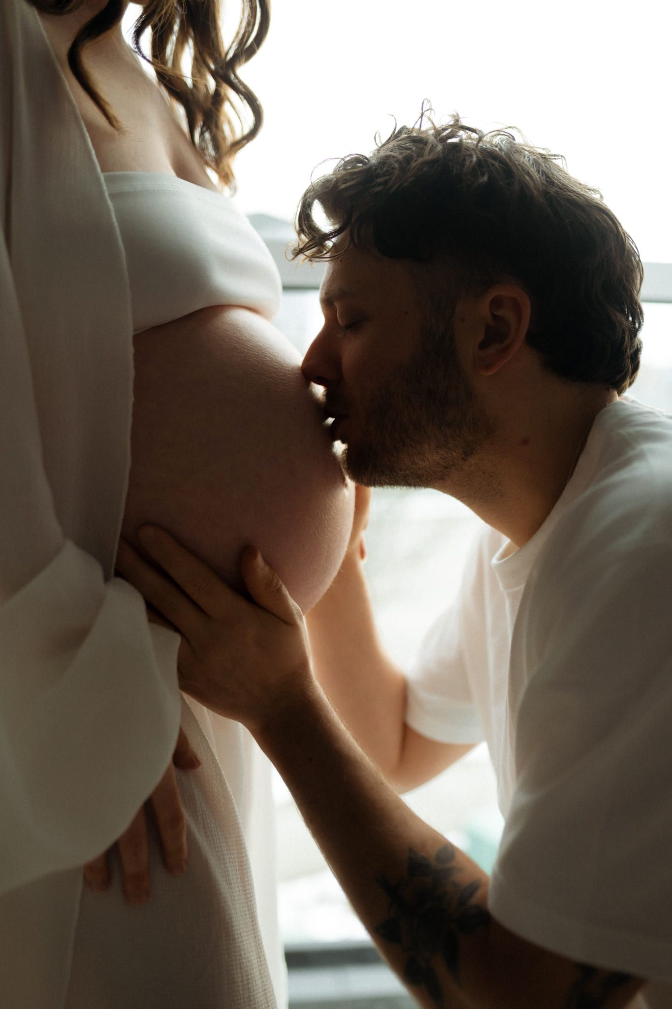 Pregnancy photography studio session, expectant couple in a white studio