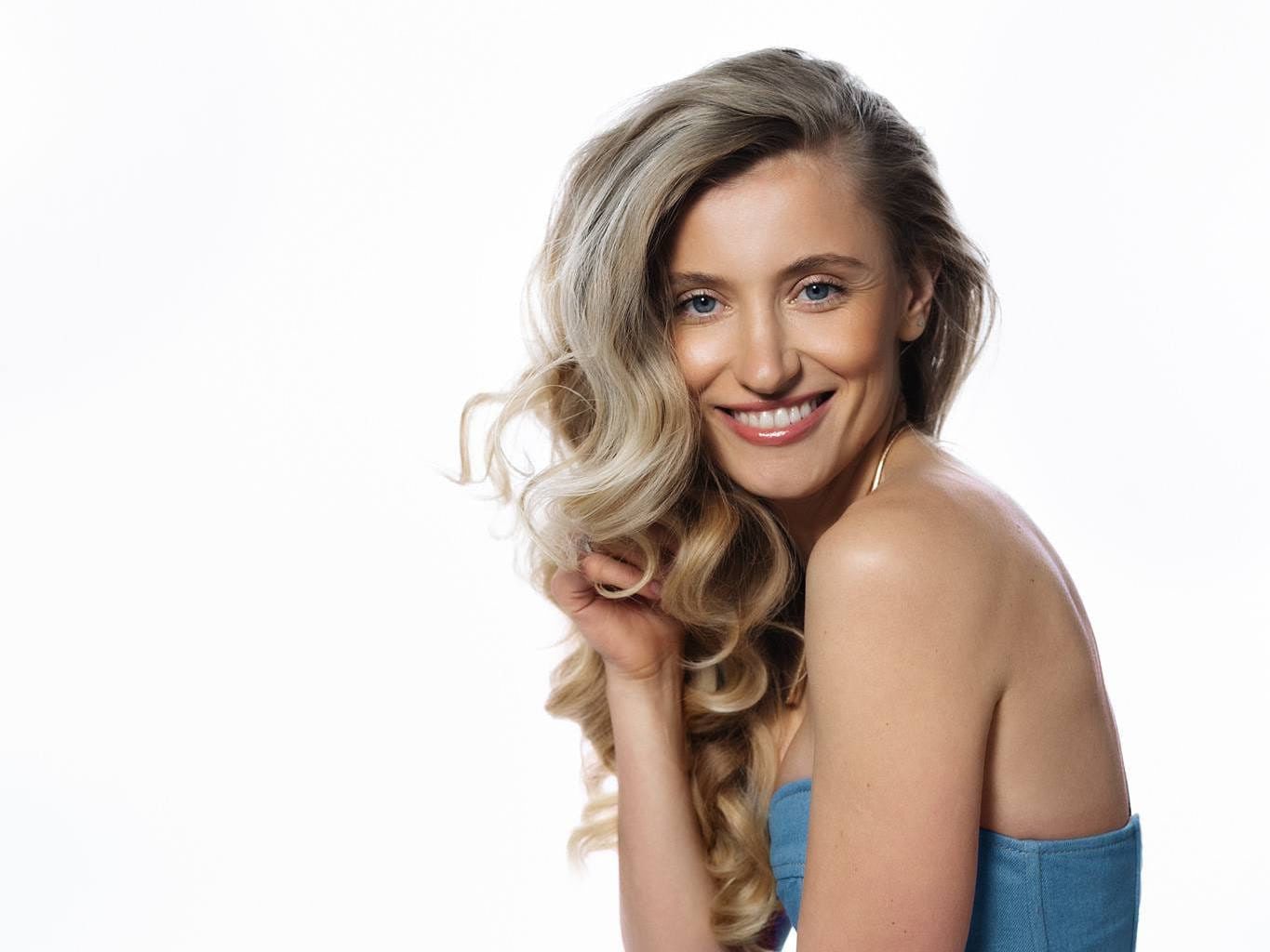 Studio portrait photography, smiling woman with wavy hair