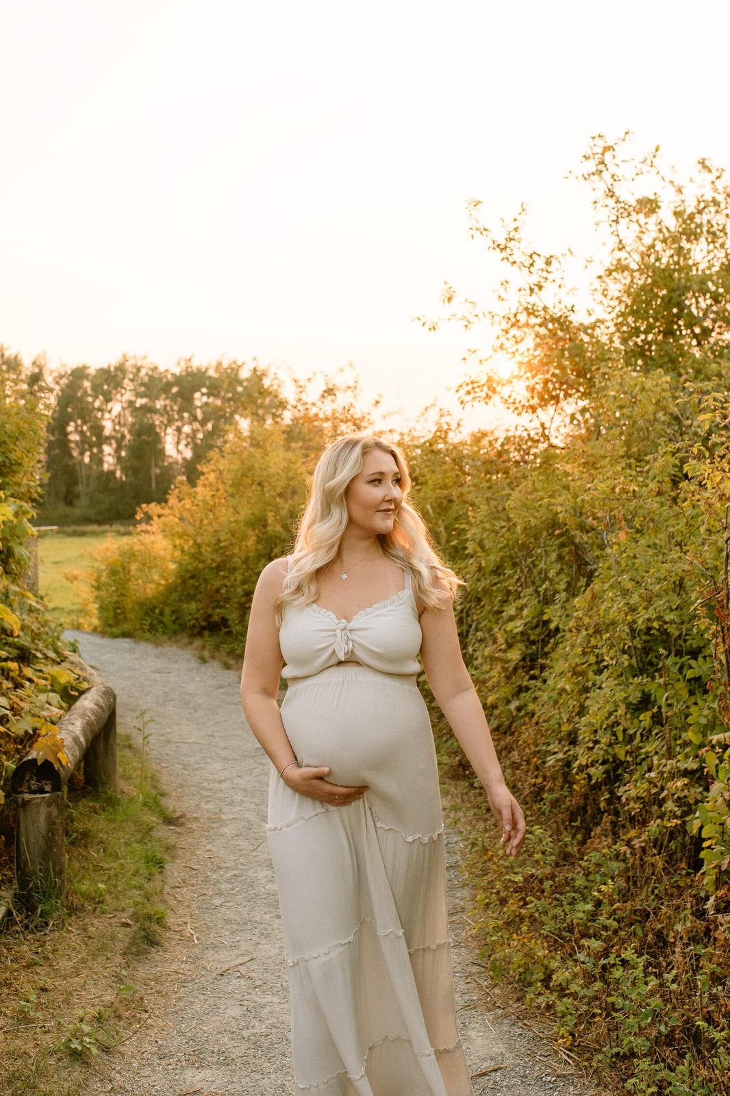 Sunset maternity shoot, mom-to-be walking a country path