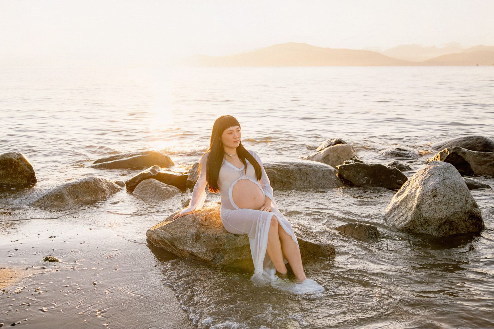 Sunset beach maternity shoot by the sea, expectant mother in a pink gown