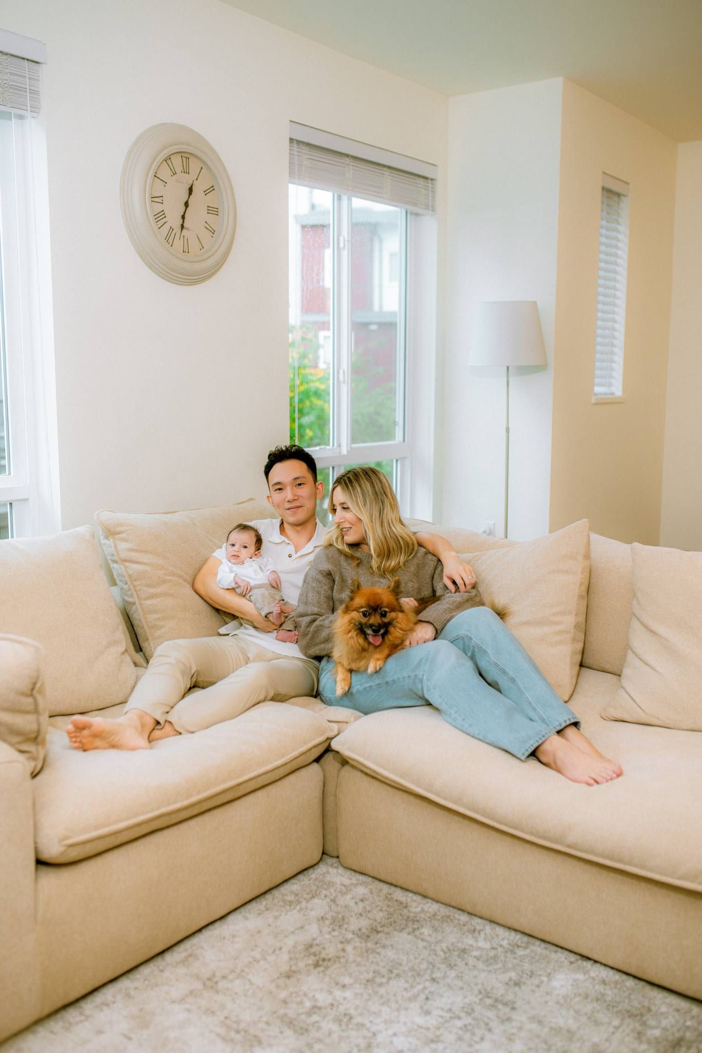 Family of three with their dog on a cream sectional sofa