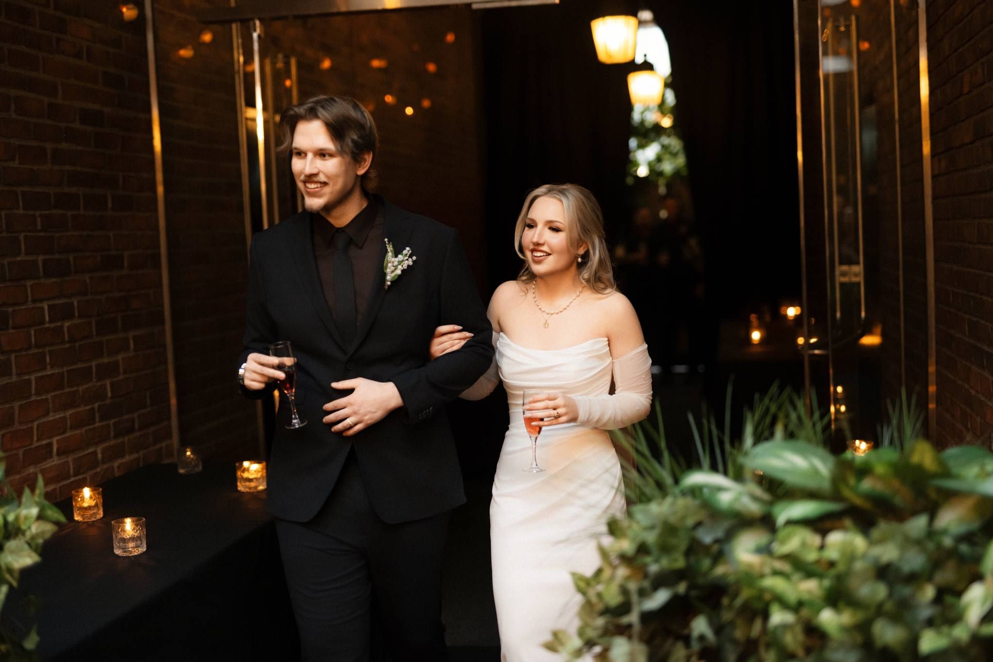 Groom escorting the bride through the ivy-covered courtyard