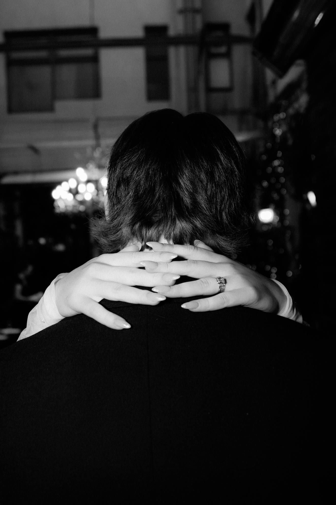 Black-and-white photo of the bride's hand on the groom's shoulder