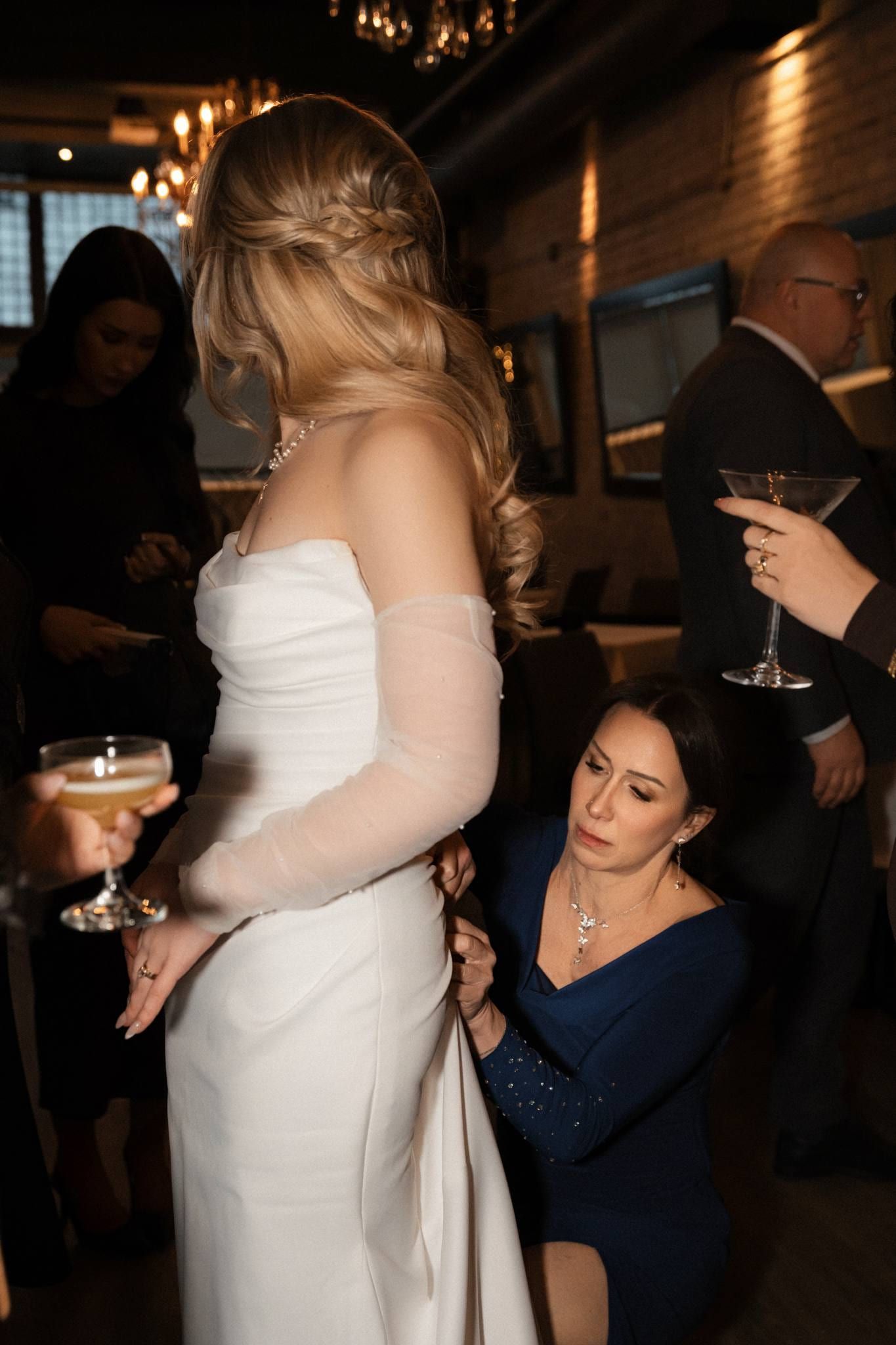 Bride in a white fur wrap chatting with guests at the reception