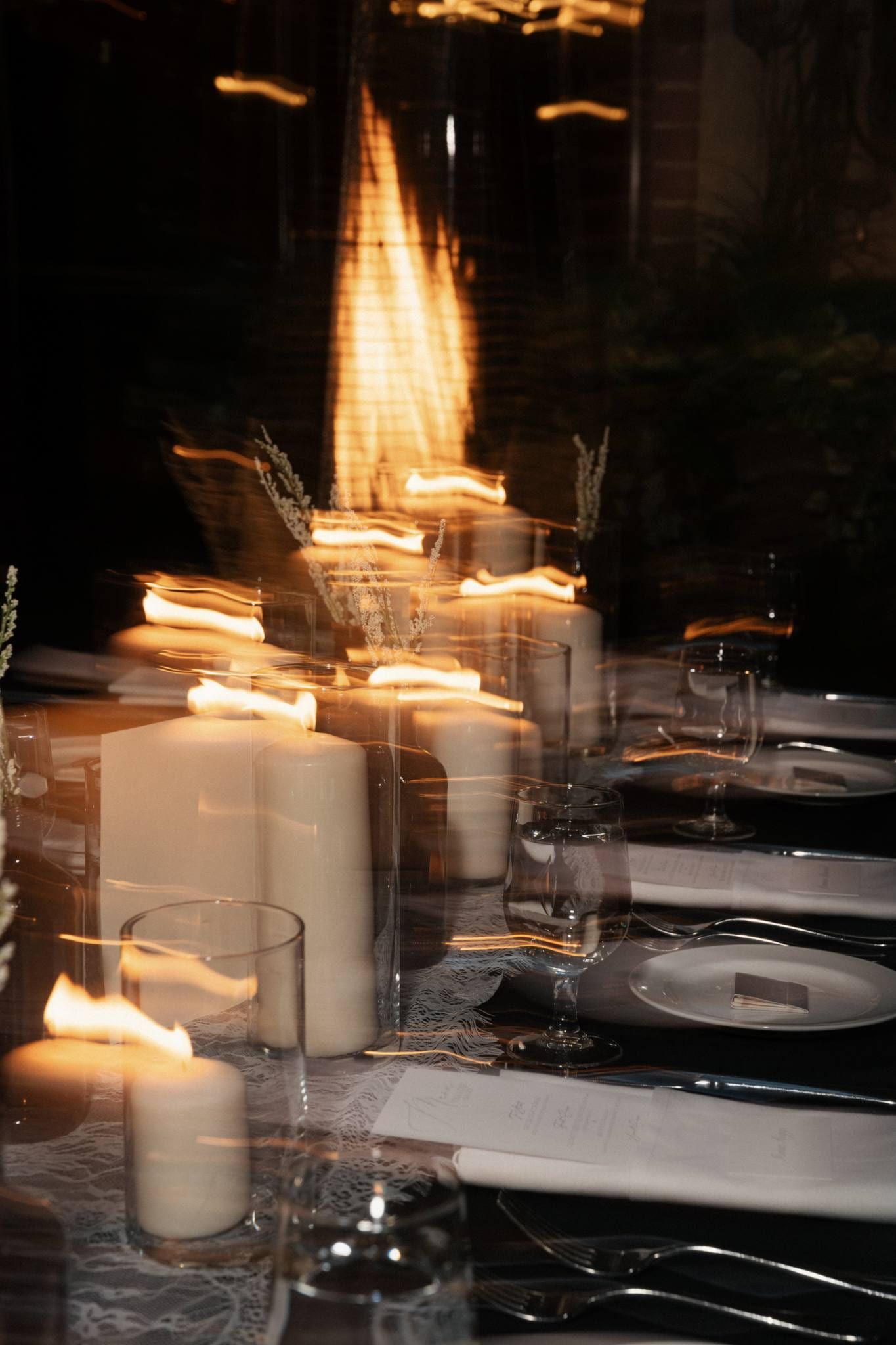 Candles glowing on a dark reception table
