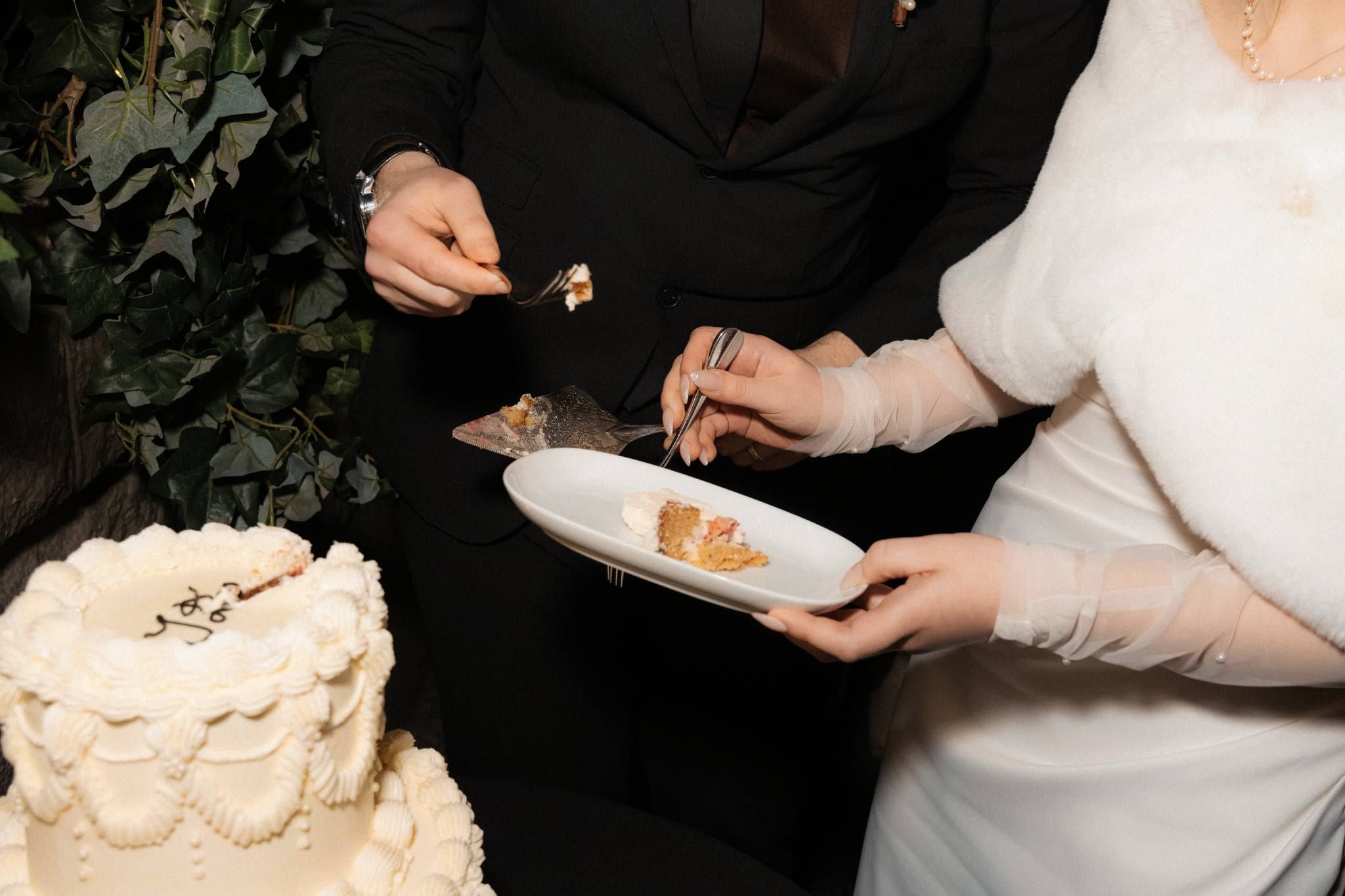 Bride in a fur wrap serving cake onto a plate