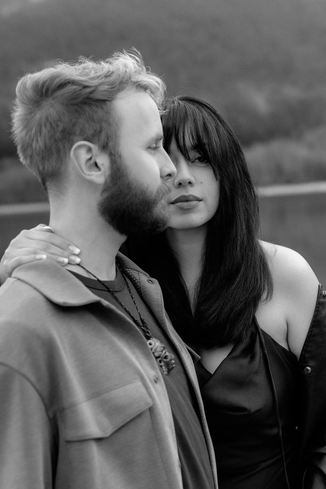 Professional engagement pictures, black-and-white close-up of a man kissing his partner's temple