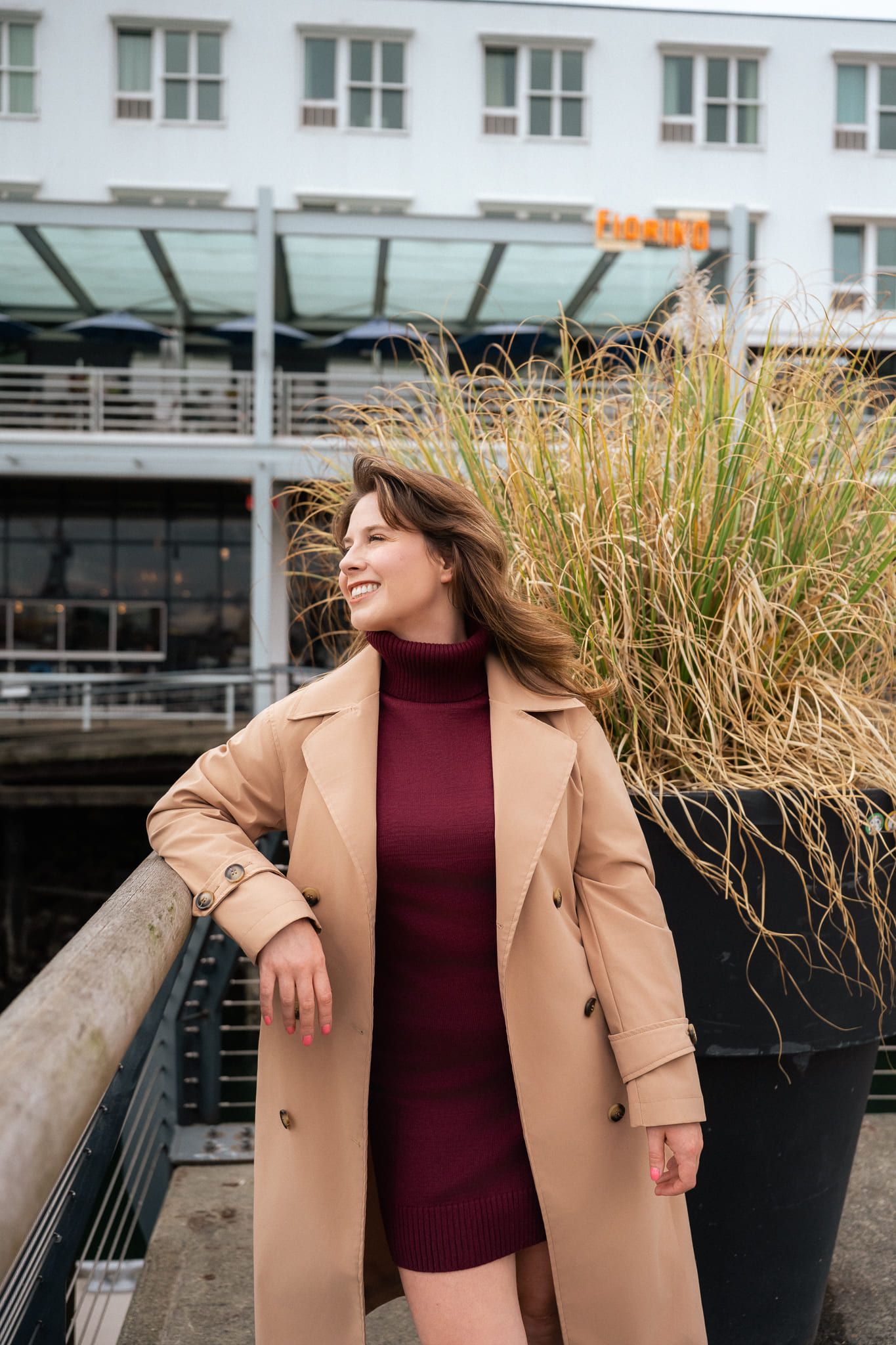 Portrait photoshoot on the waterfront, woman in a camel trench coat
