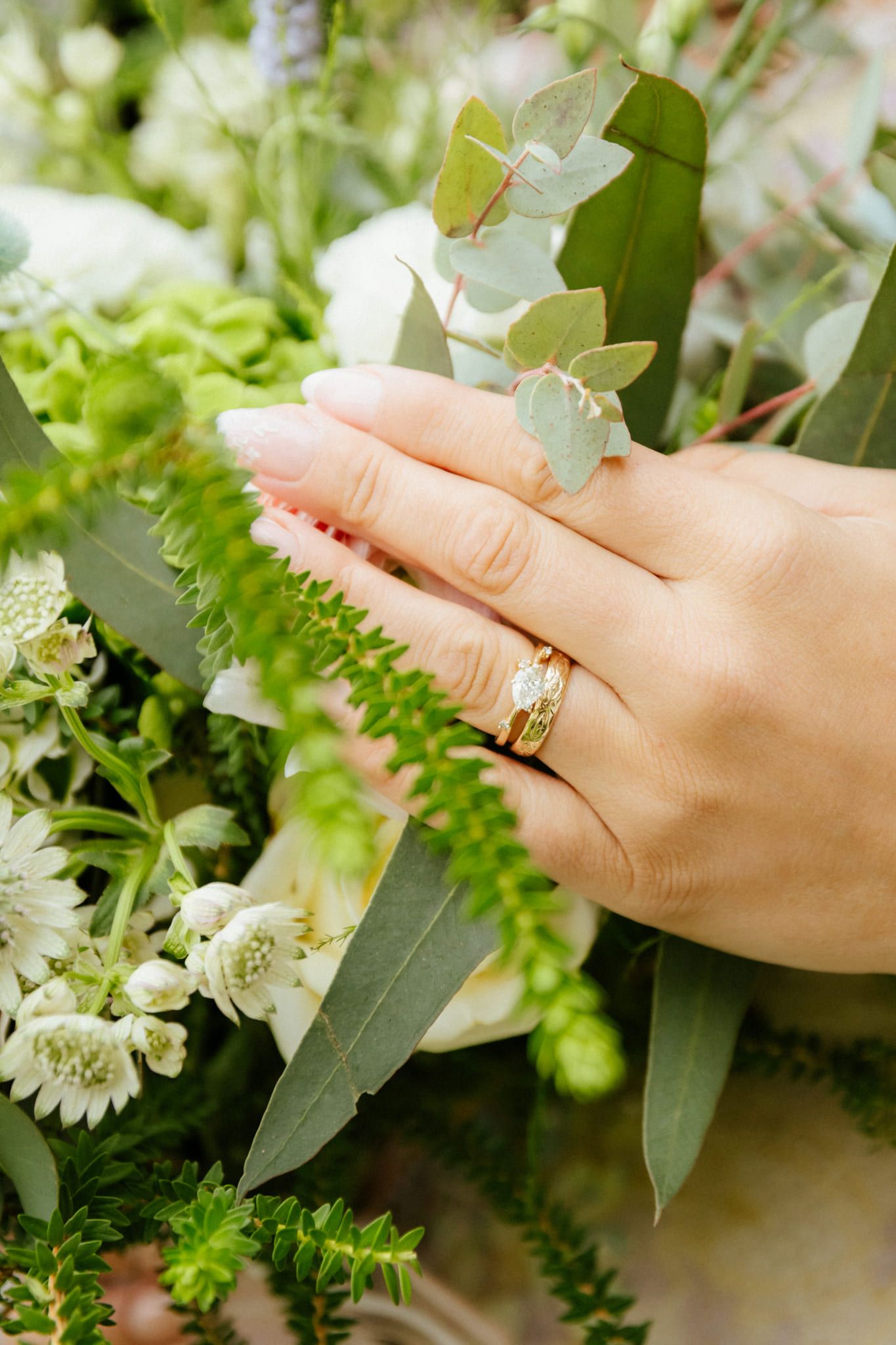 Close-up of the bride's hand with her ring on a bouquet of white flowers and greenery, by Langley elopement photographer Natalie Varro