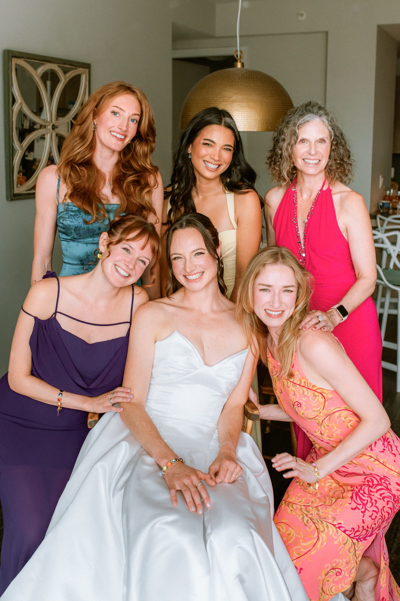Modern wedding photos, bride surrounded by her bridesmaids in bright dresses