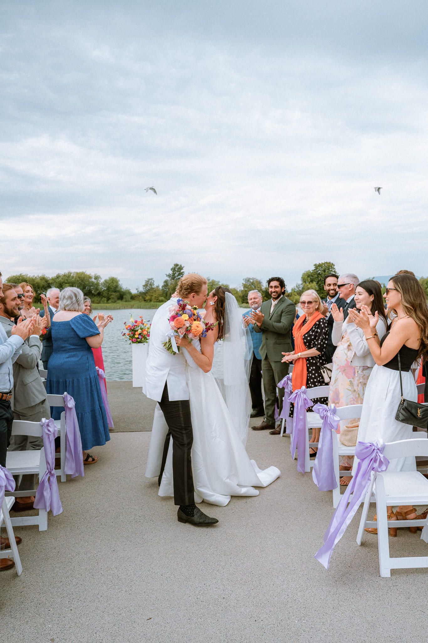 Elopement photos, bride and groom kissing at the end of the aisle as guests cheer