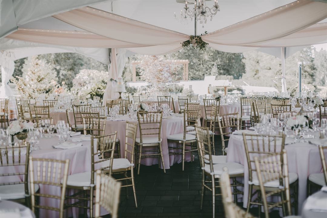Simple wedding photos, reception tables with gold chairs under a draped tent at Redwoods Golf Course