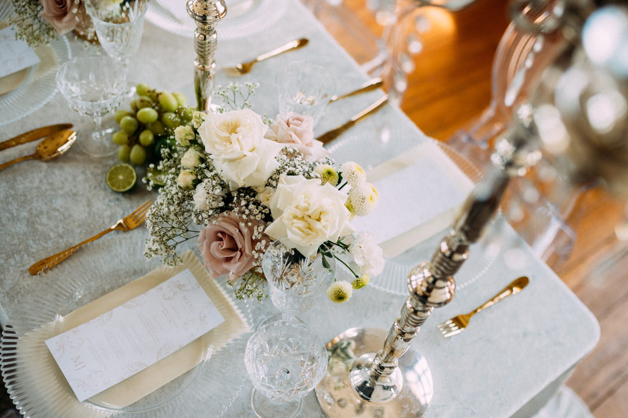 Pre-bridal shoot, reception table set with pale roses, crystal and gold cutlery