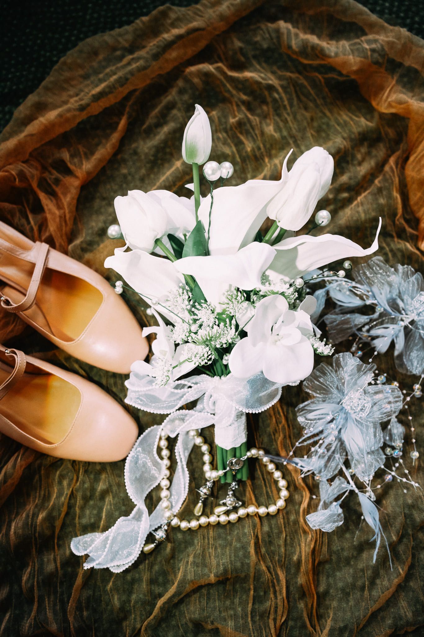 Intimate wedding photos, bridal bouquet of white lilies with shoes and pearls