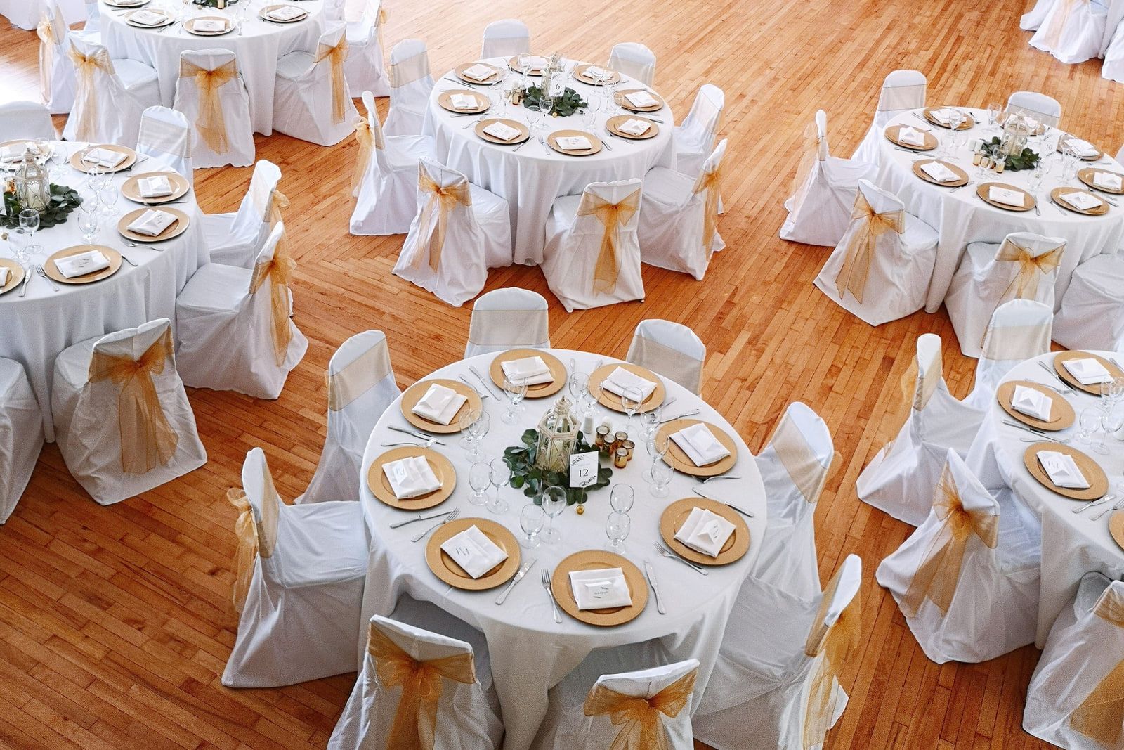 Wedding shoot, round reception tables set in white on the wooden floor of Fort Langley Community Hall