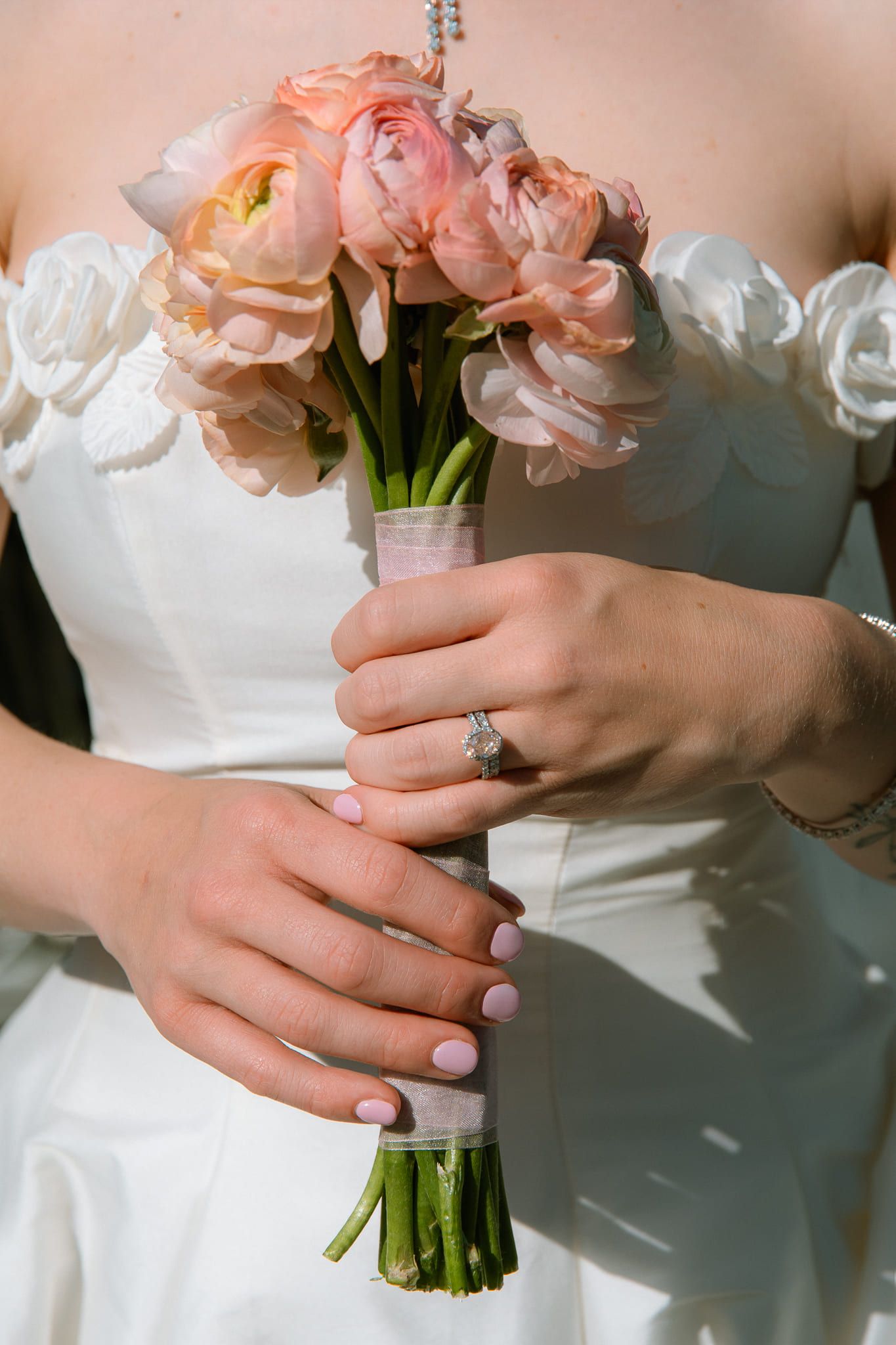 Wedding details photo, close-up of the bride holding a bouquet of pink roses
