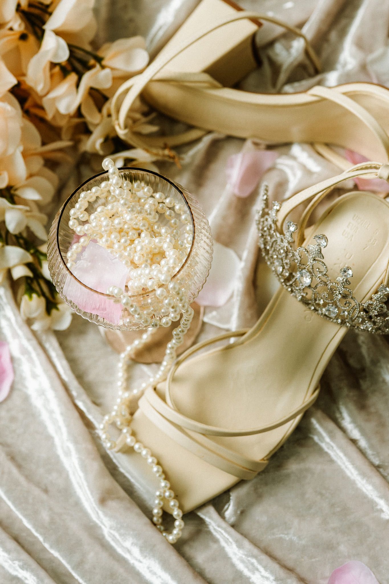 Wedding photos, bridal shoes, pearls and a tiara on satin