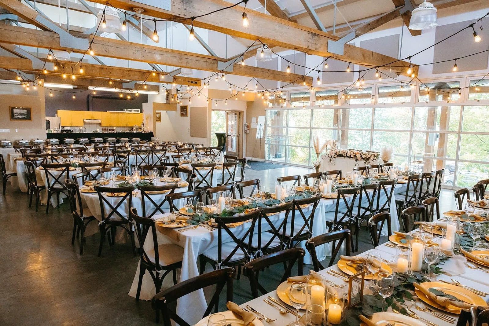 Creative wedding photos, long tables set for a wedding under a timber ceiling