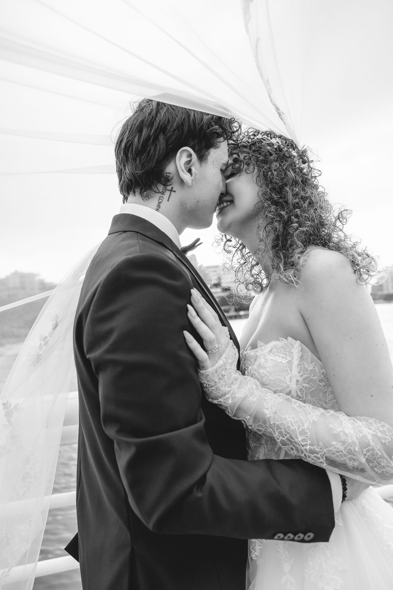 Black and white wedding photo of the bride and groom touching foreheads