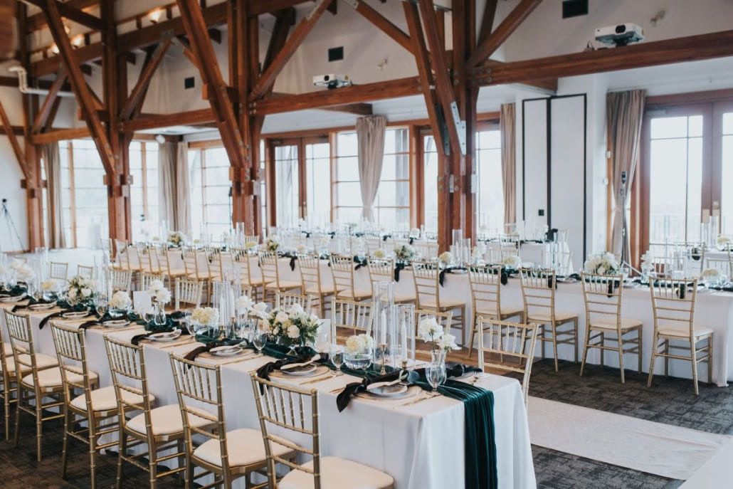Small wedding photography, timber-framed room with long tables set for a wedding