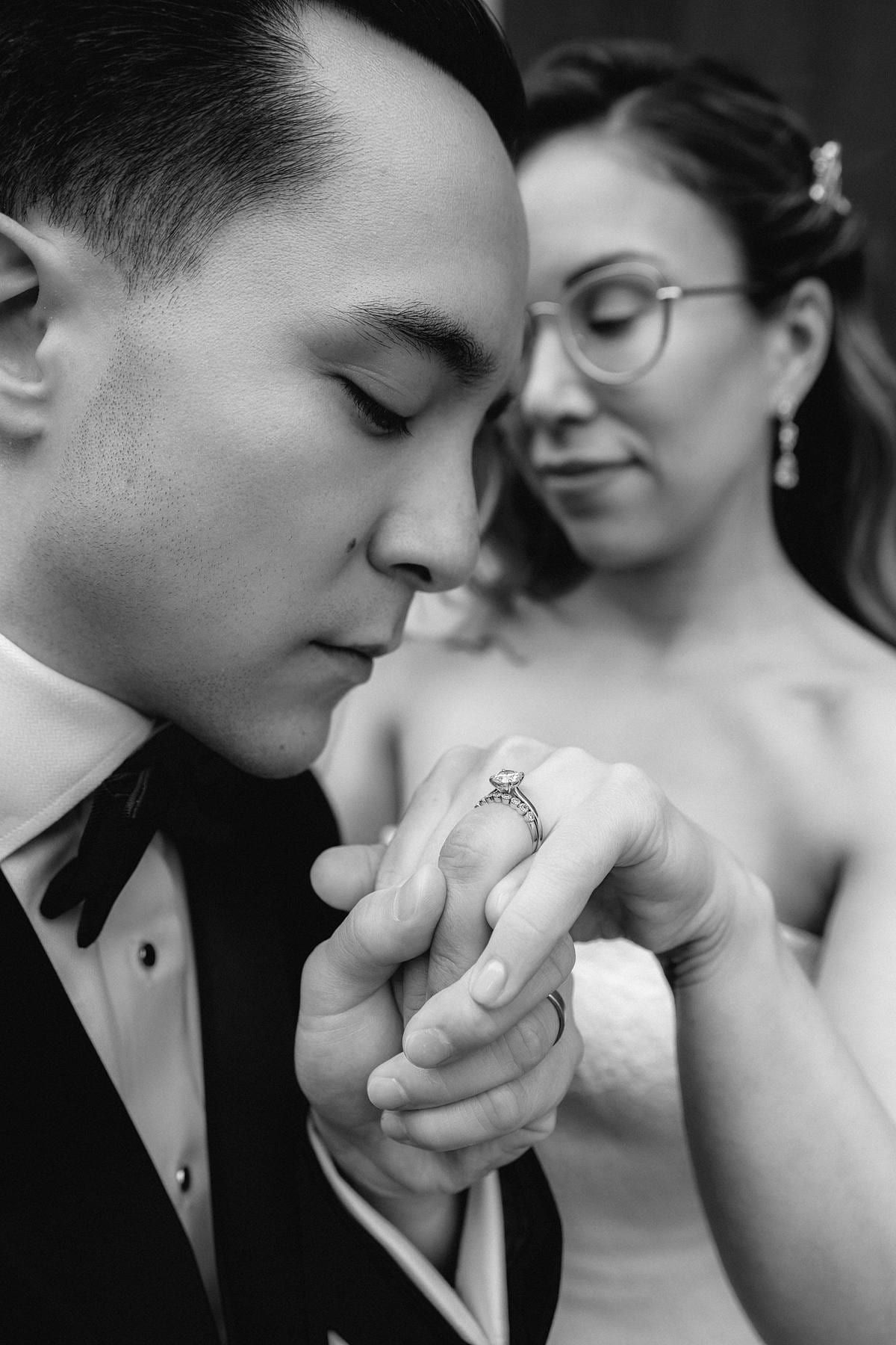 Wedding details photo, black-and-white close-up of the couple forehead to forehead, hands clasped