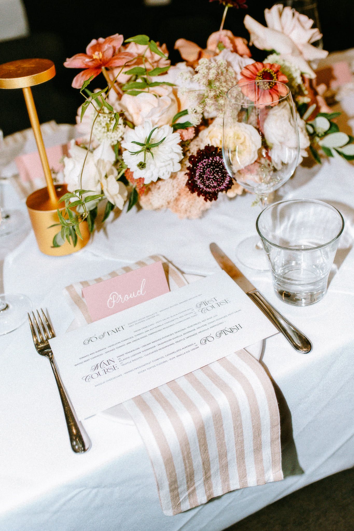 Wedding photoshoot, reception place setting with peach flowers and a striped napkin