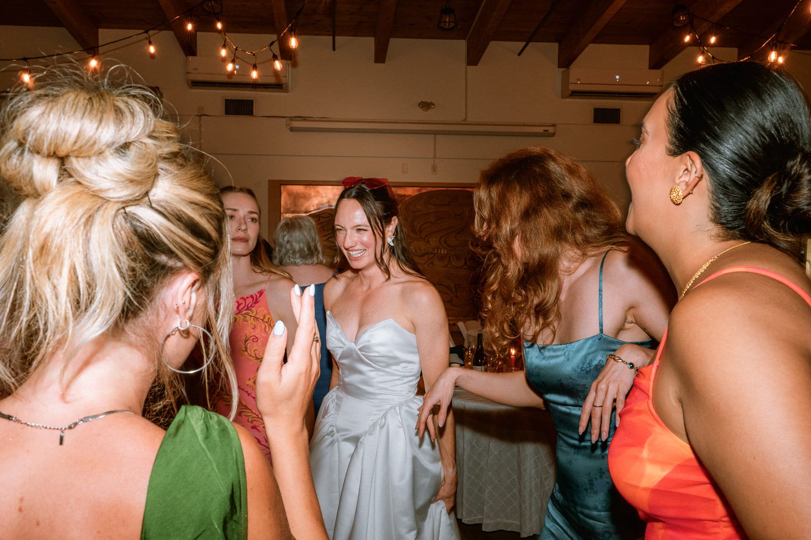 Candid wedding photos, bride dancing with her friends at the reception