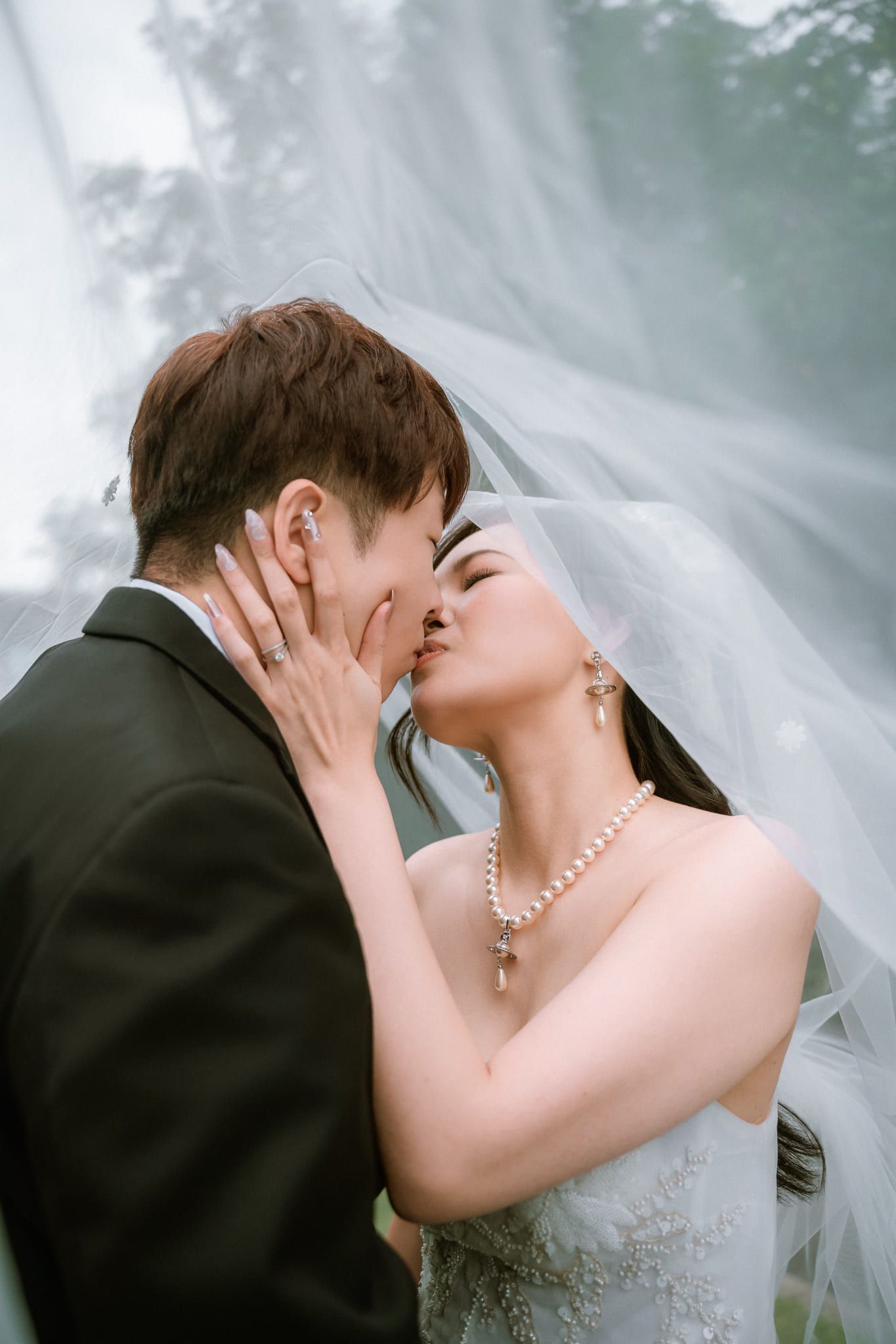 Elopement photoshoot, bride and groom kissing under her veil