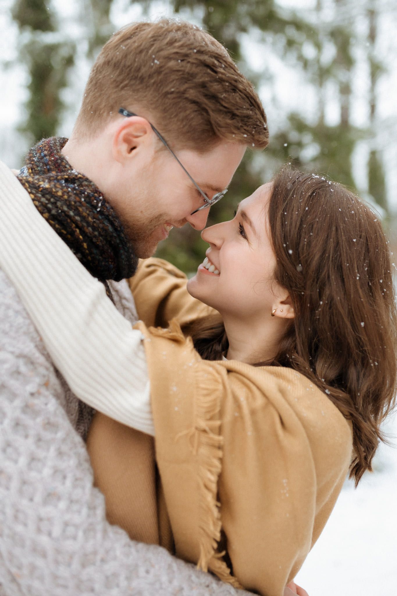 Winter engagement shoot in the snow, couple laughing nose to nose
