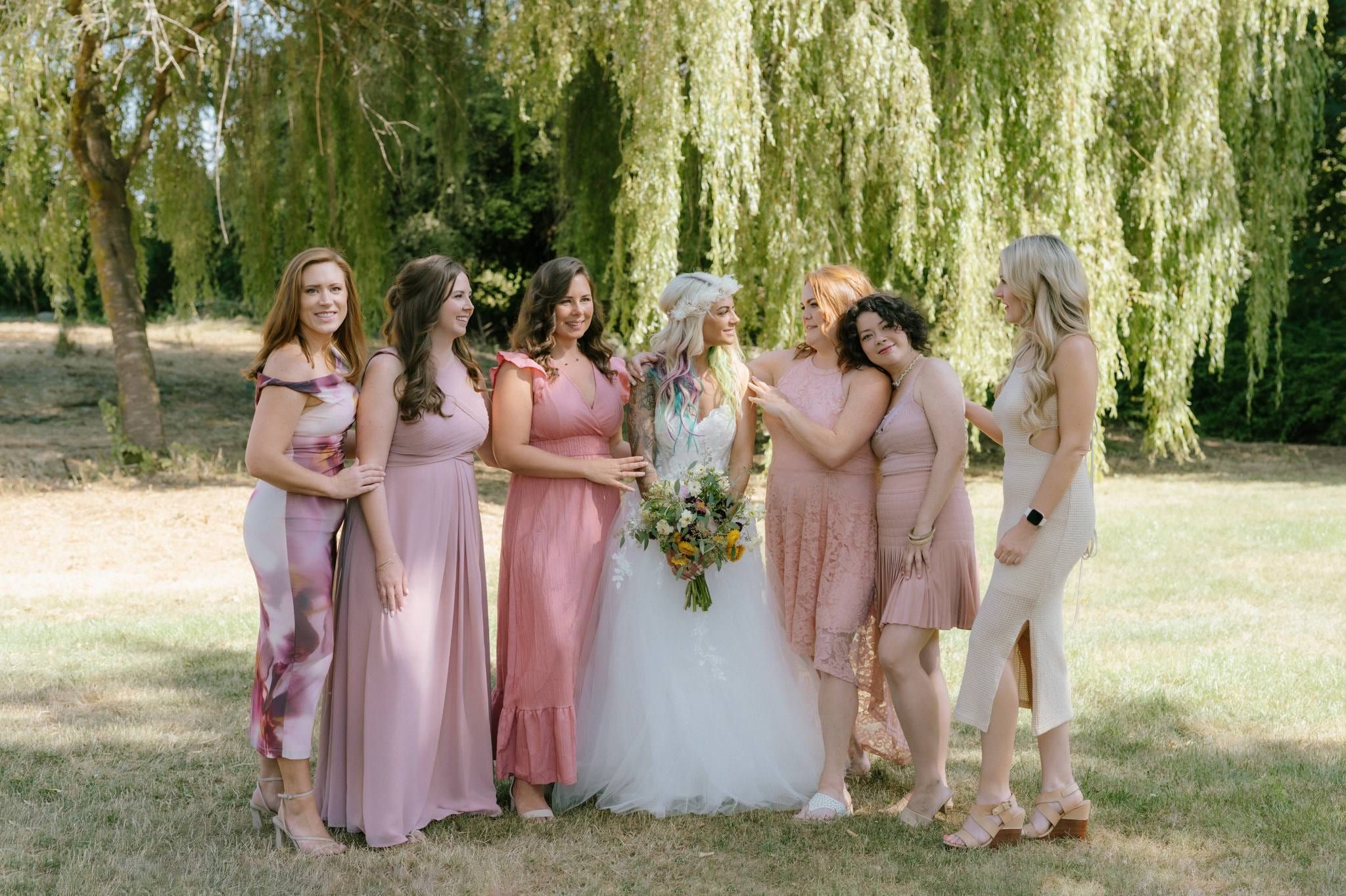 Bride and bridesmaids in pink beneath the willow tree