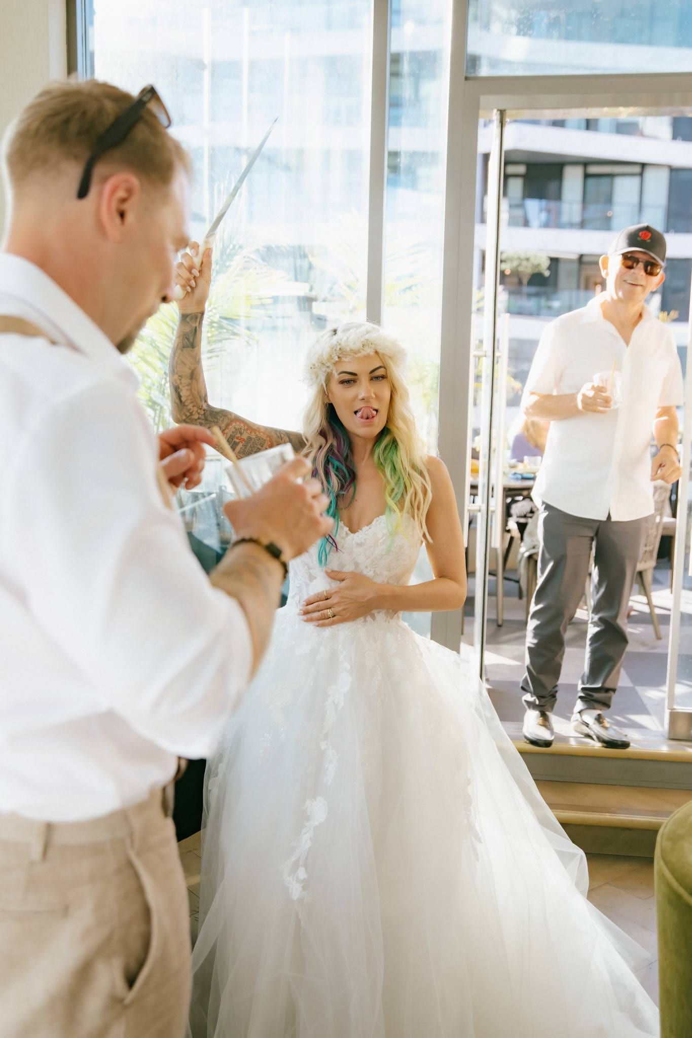 Groom and bride laughing with a guest at the reception