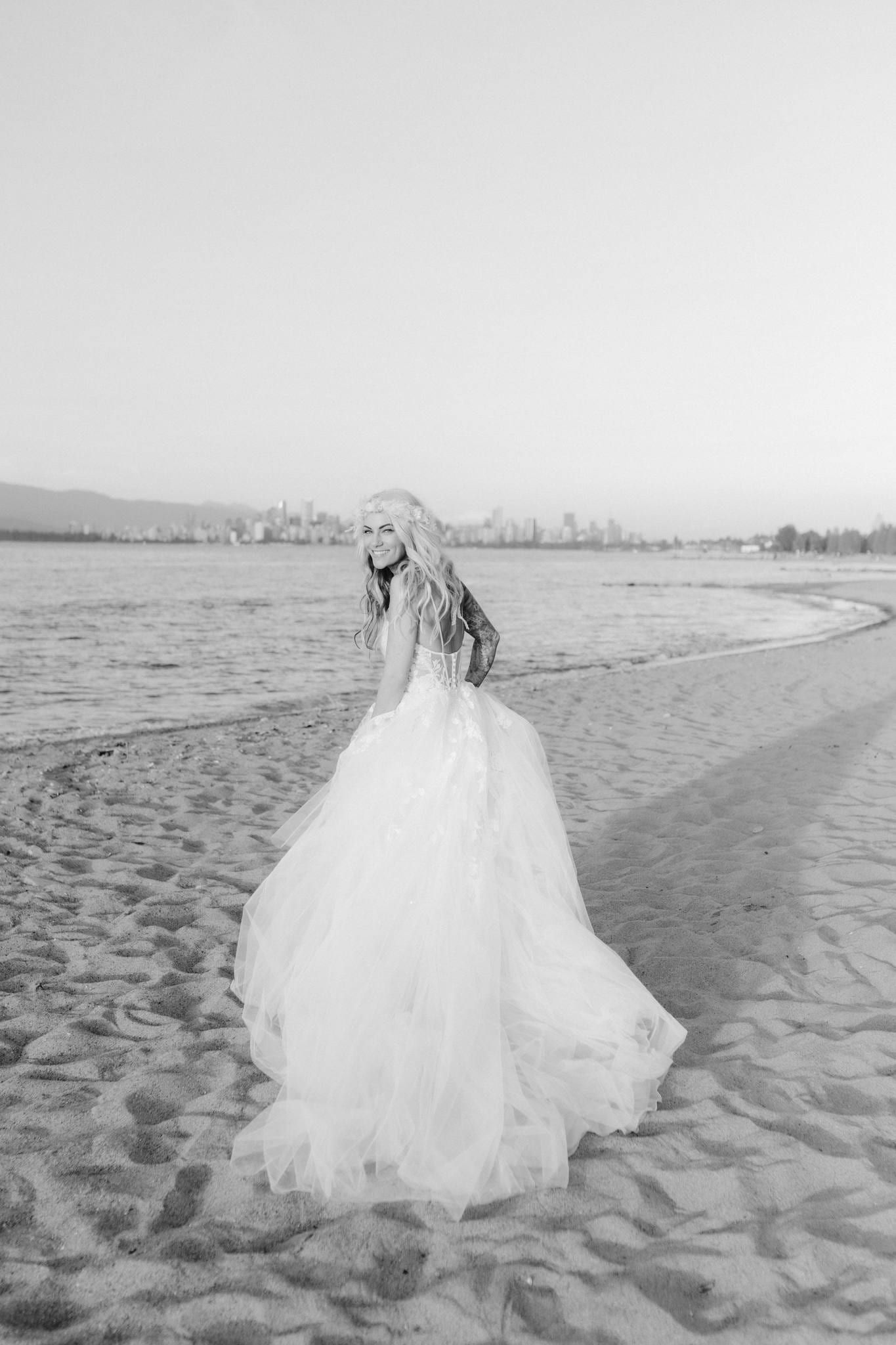 Black-and-white photo of the bride walking along the beach