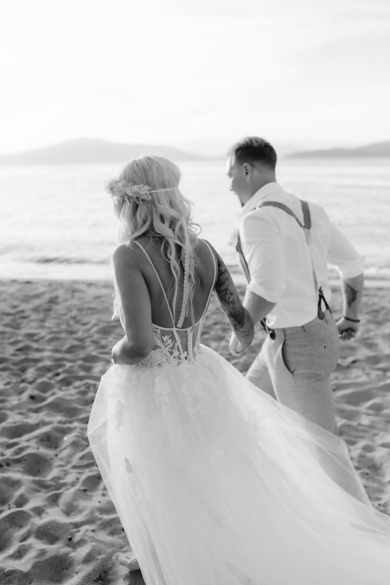 Black-and-white photo of the couple walking along the beach