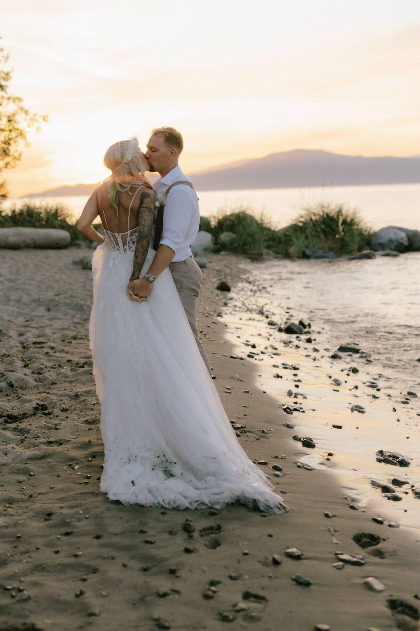 Couple kissing on the beach with the water at their feet