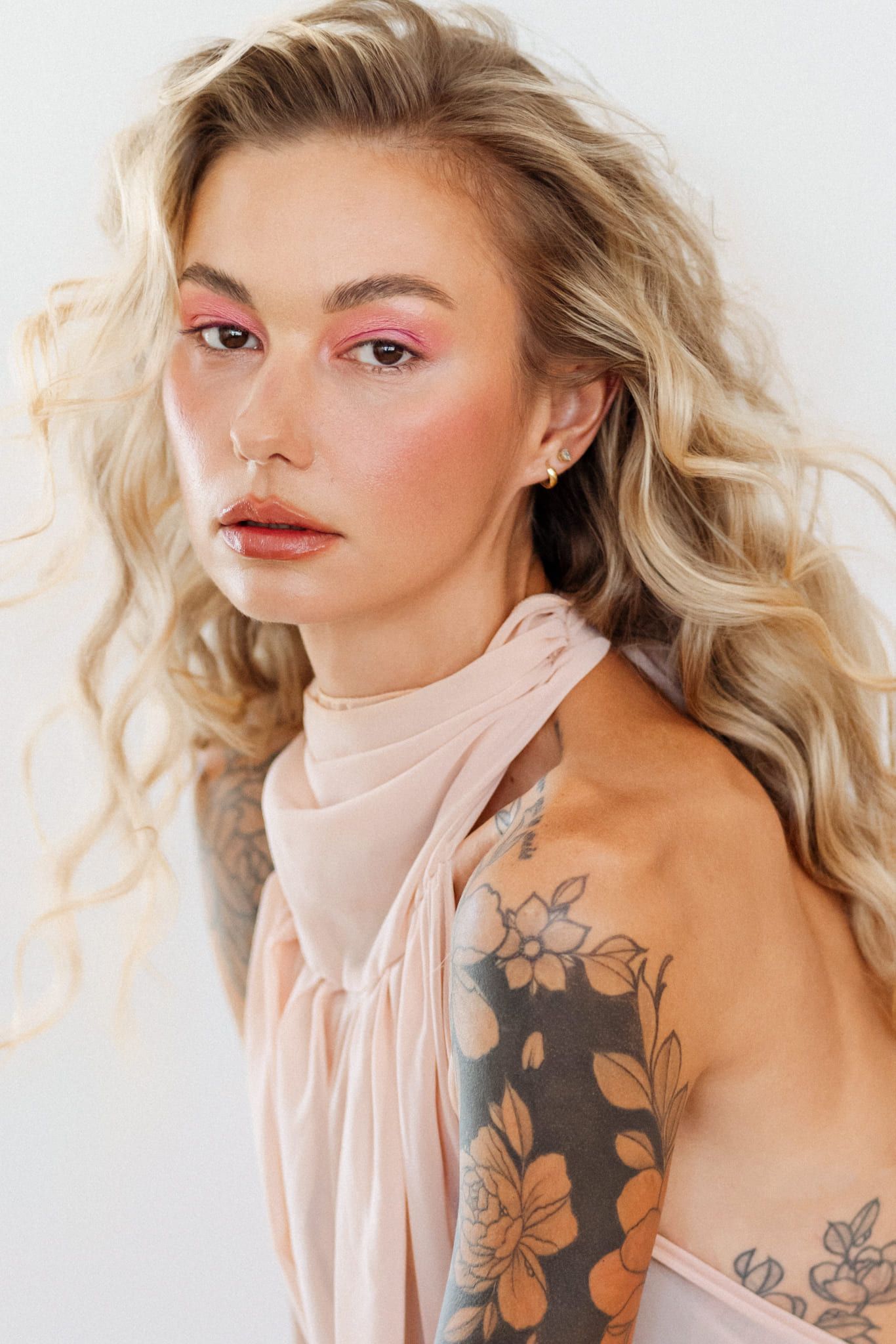 Branding photoshoot, close-up portrait of a woman with blonde waves and a tattooed shoulder